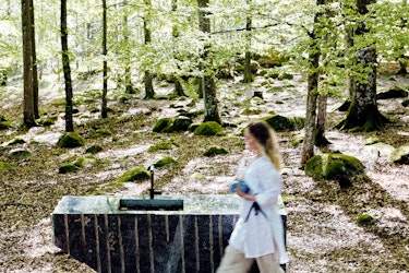 A raw stone block in Bøkeskogen in Larvik with a woman in front