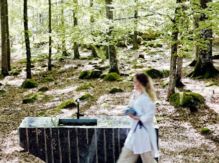 A raw stone block in Bøkeskogen in Larvik with a woman in front