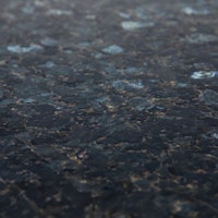 A black stone surface with structure and grey crystals